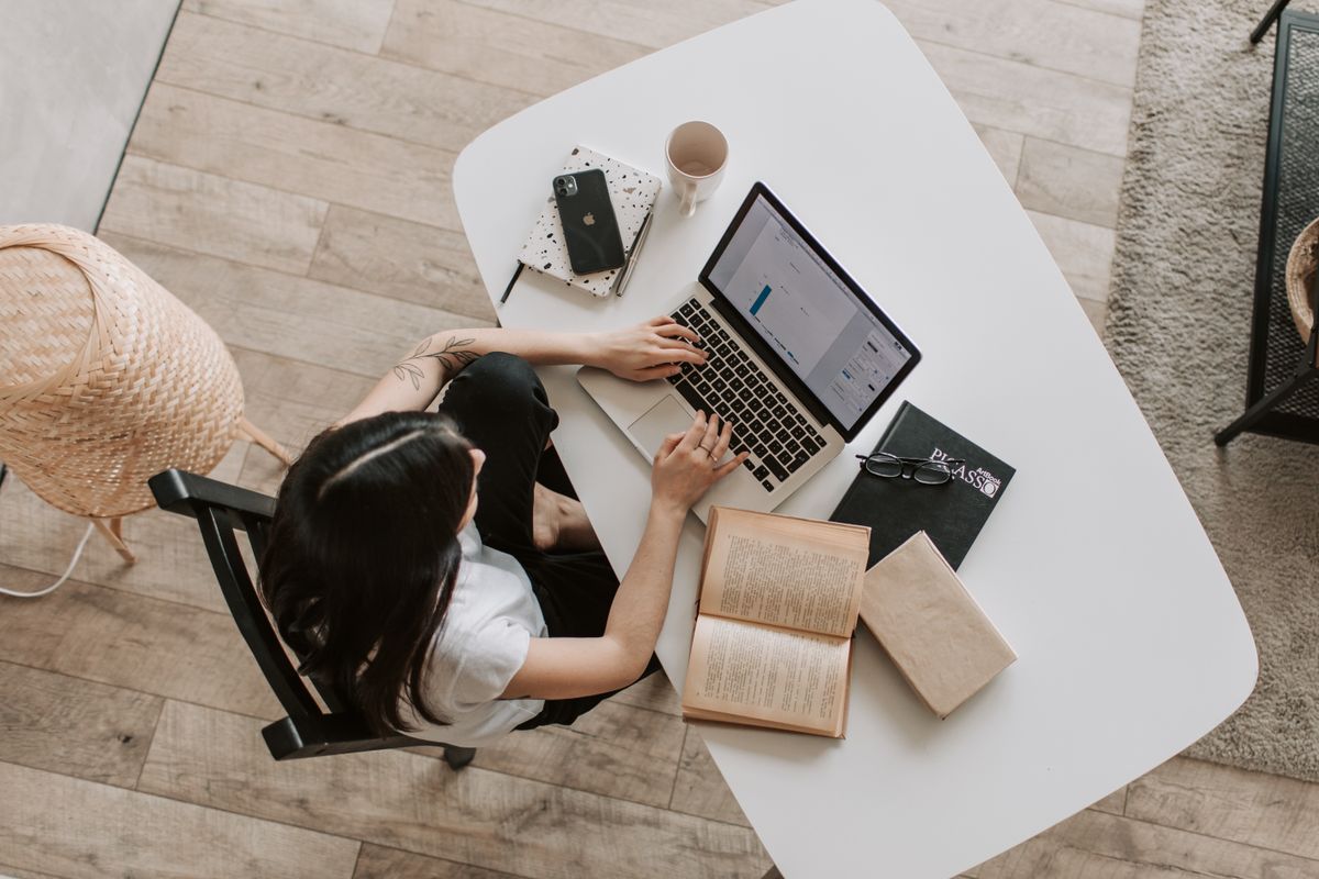 Person working with a notebook and laptop