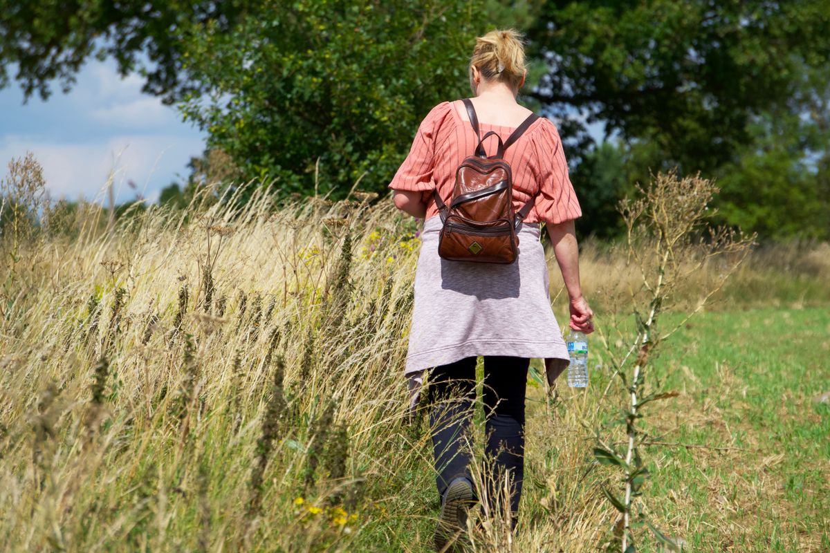A woman enjoying a peaceful walk across a grassy field